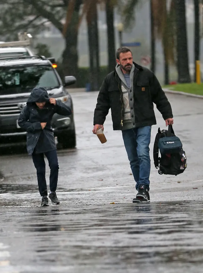 Ben Affleck y su hijo Samuel bajo la lluvia.