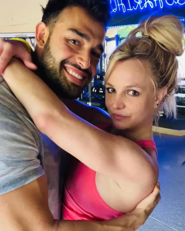 Britney Spears con sus brazos alrededor del cuello de Sam Asghari.