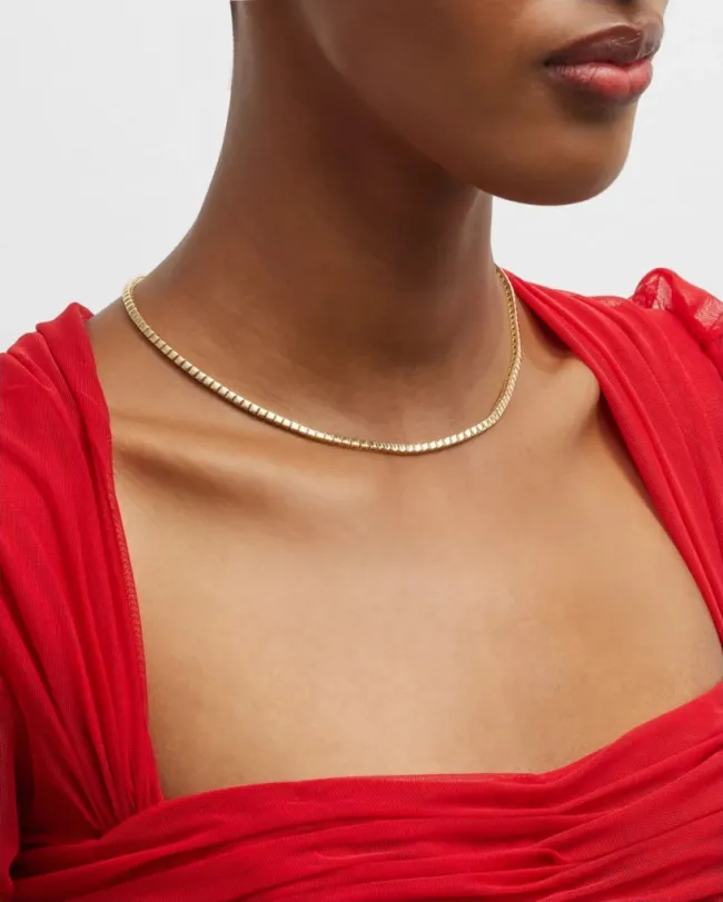 Una modelo vestida de rojo y un collar de tenis de Jennifer Meyer en oro de 18 quilates.