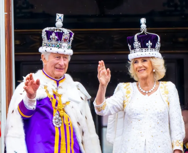 El rey Carlos y la reina Camilla saludan a la multitud.