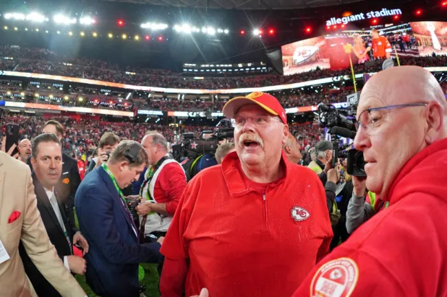 El entrenador de los Chiefs, Andy Reid, rodeado de gente en el campo de fútbol del Super Bowl 2024.