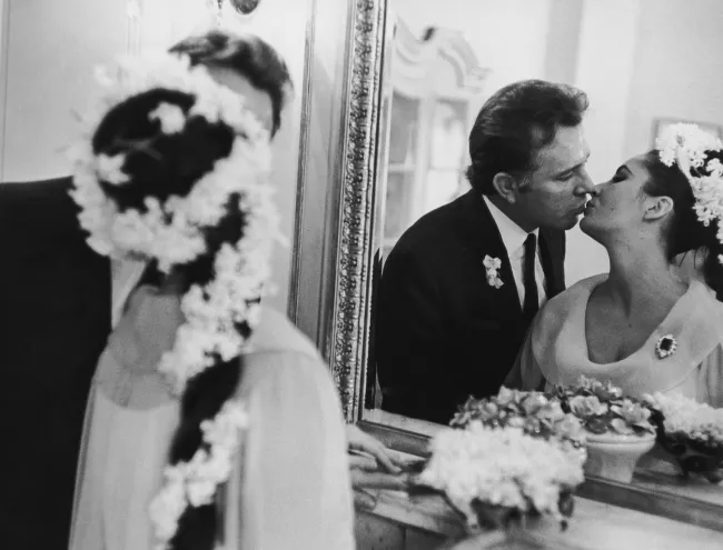 Elizabeth Taylor y Richard Burton besándose en su primera boda, vistos en un espejo