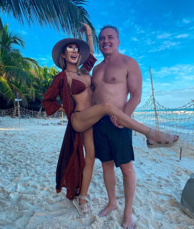 Lenny Hochstein sosteniendo la pierna de Lisa Hochstein en la playa