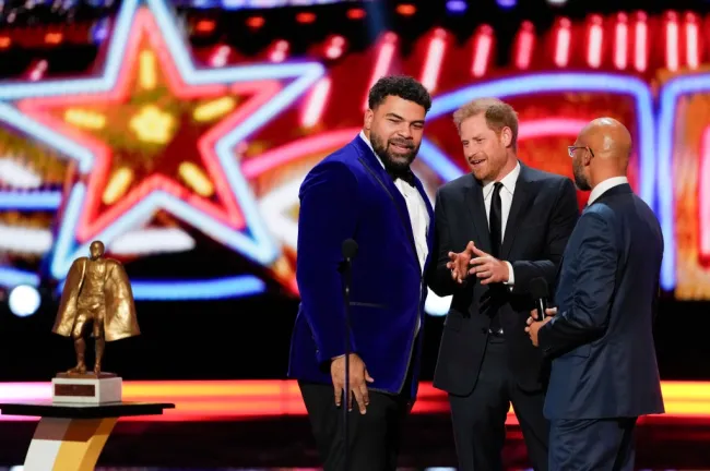 El príncipe Harry habla con Cameron Heyward mientras el cómico Keegan-Michael Key observa.