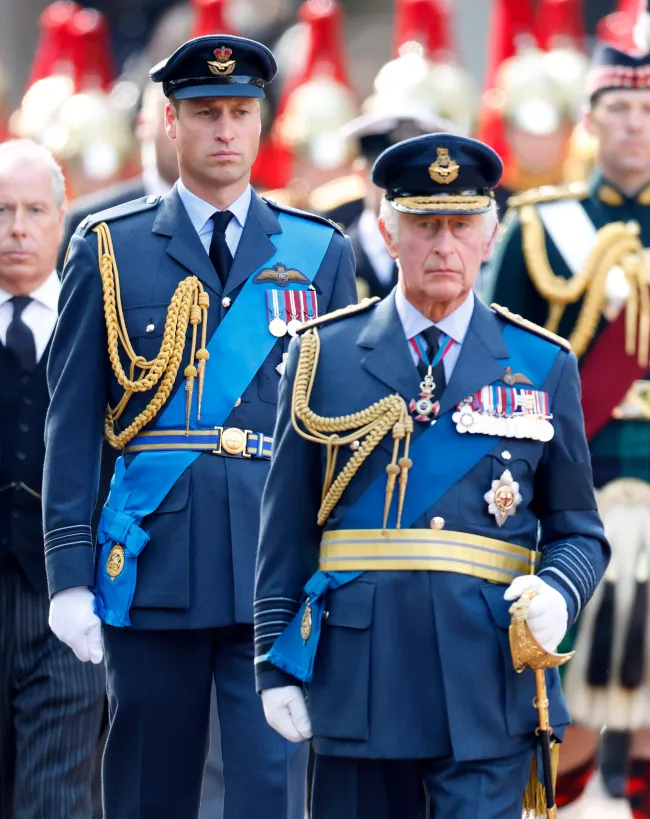 El príncipe William y el rey Carlos caminando detrás del ataúd de la reina Isabel II en 2022.
