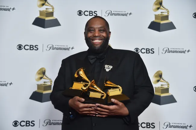 El rapero Killer Mike sosteniendo tres Grammys.