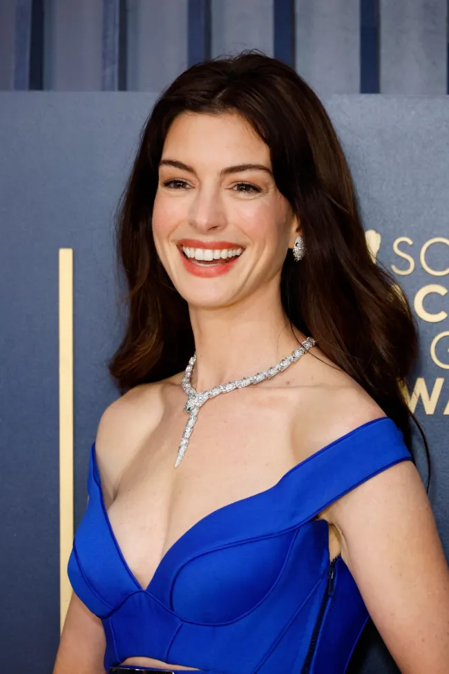 Anne Hathaway con un vestido azul en la alfombra roja.