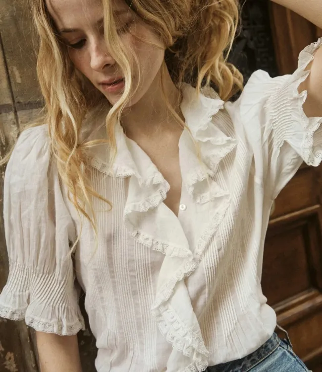 Una modelo con una blusa blanca.