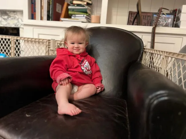 Bennett, la hija de 1 año de Jason y Kylie Kelce, sentada en un sofá de cuero