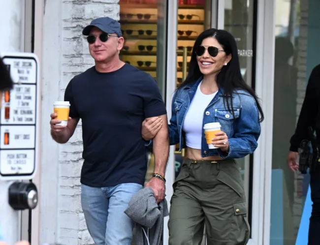 Jeff Bezos y su prometida Lauren Sánchez paseando con cafés.