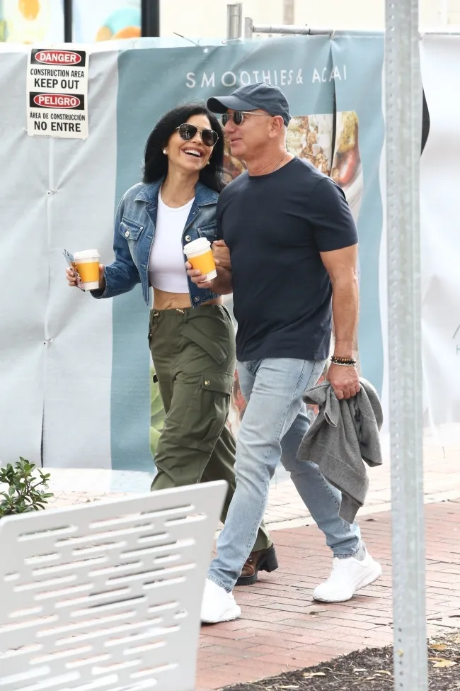Jeff Bezos y su prometida Lauren Sánchez paseando con cafés.