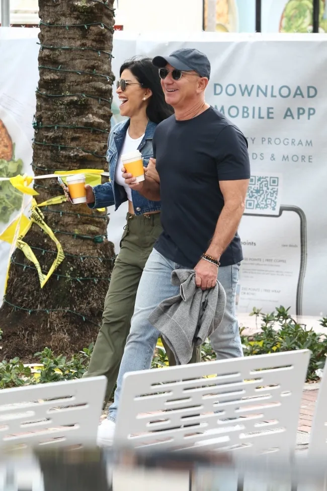 Jeff Bezos y su prometida Lauren Sanchez paseando con cafés.