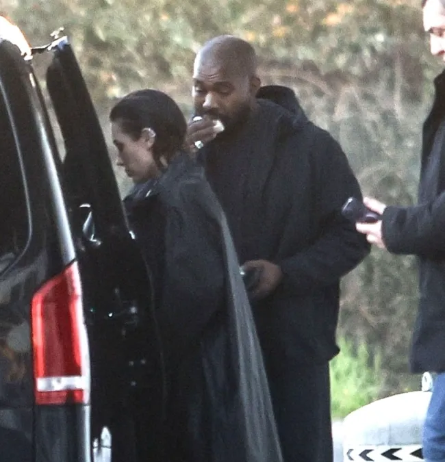 Kanye West subiéndose a un auto con Bianca Censori.