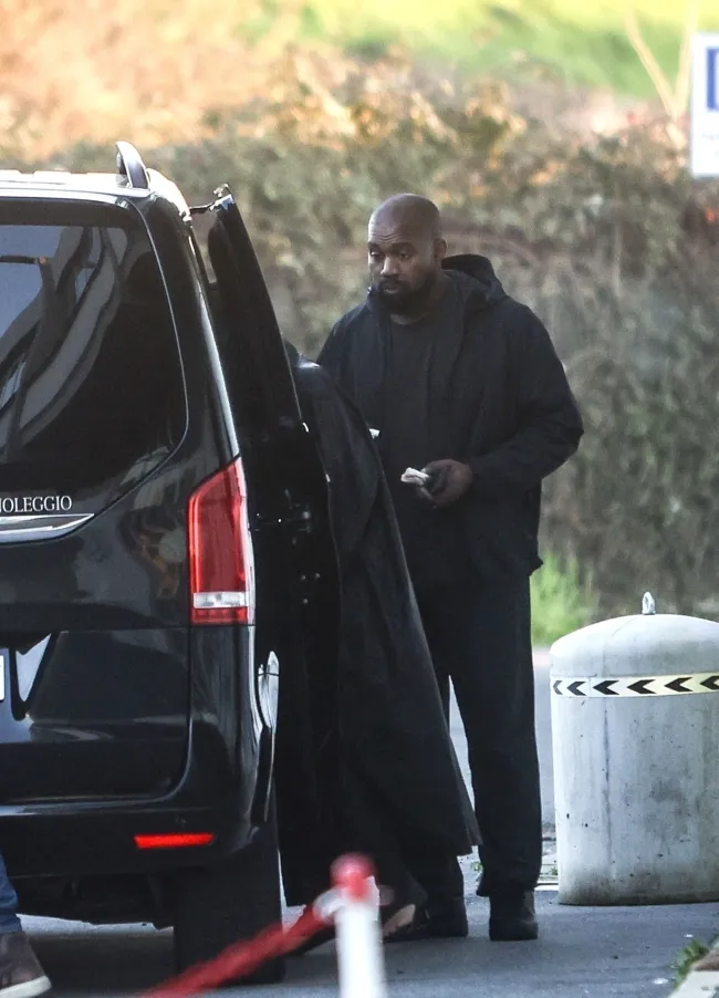 Kanye West parado junto a un coche.