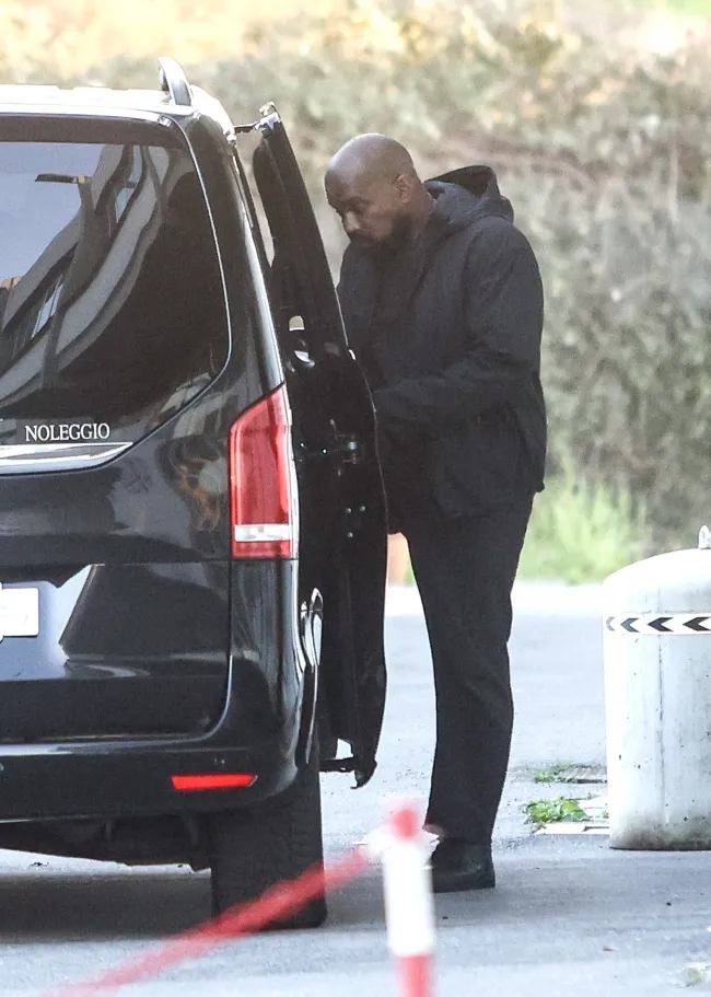 Kanye West subiéndose a un coche.