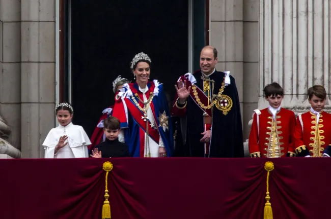 la princesa charlotte, kate middleton, el príncipe louis, price middleton, el príncipe george y otro niño saludando desde un balcón