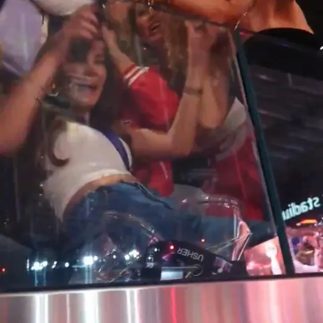 Taylor Swift cayendo encima de una mujer en una suite vip.