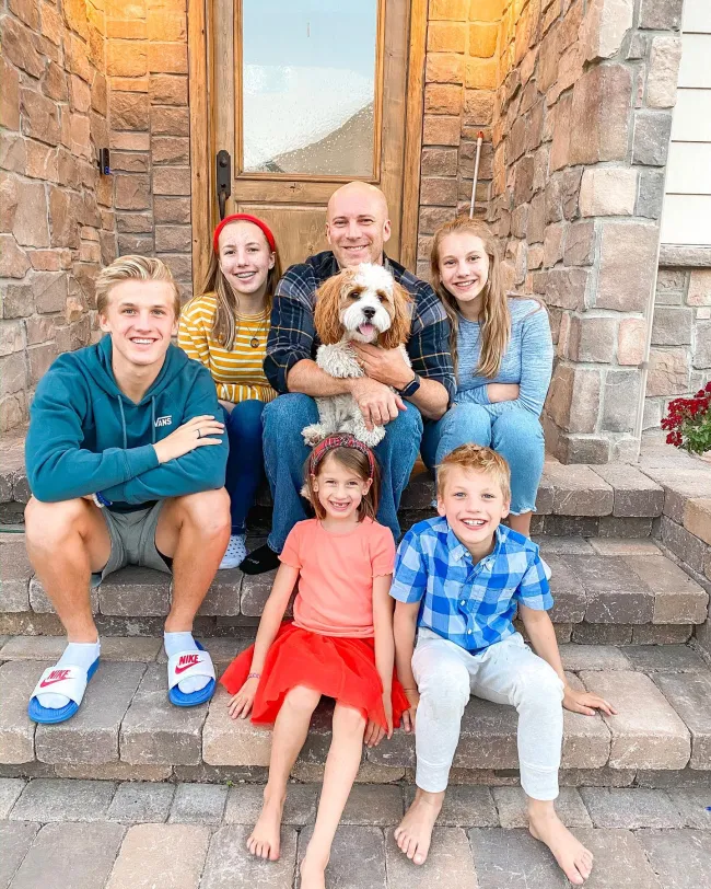 Kevin Franke sentado en el porche con sus hijos y su perro.