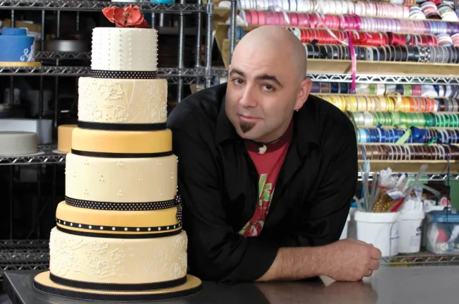 Duff Goldman junto a un pastel de 6 niveles