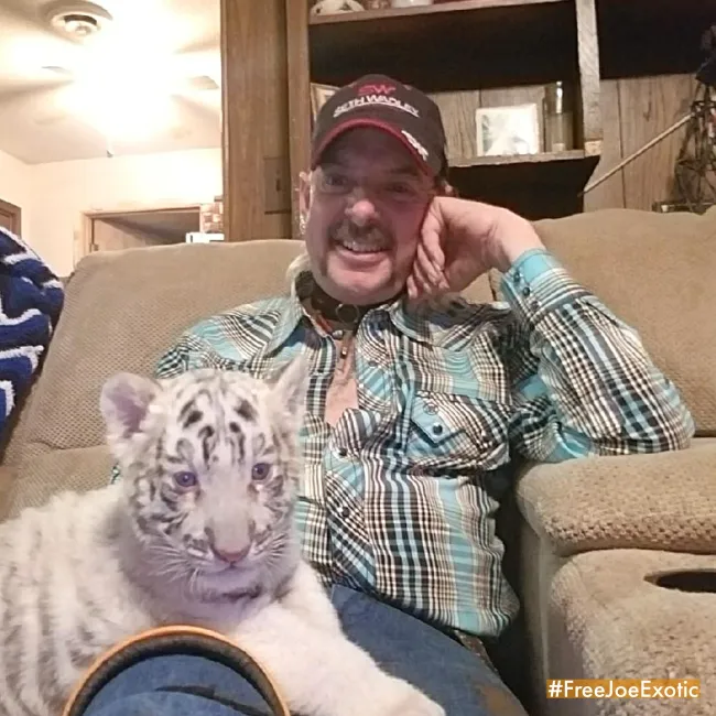 Joe exótico en un sofá con un tigre blanco.