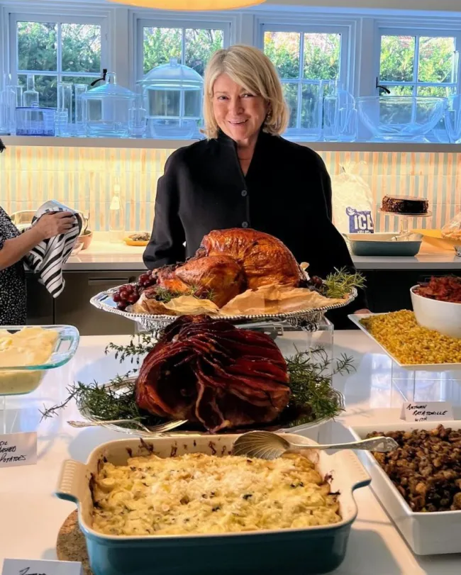 Martha Stewart posando con comida en la mesa para el Día de Acción de Gracias.