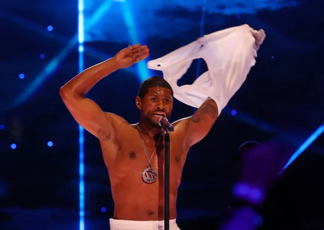 Usher se quita la camisa frente a un micrófono