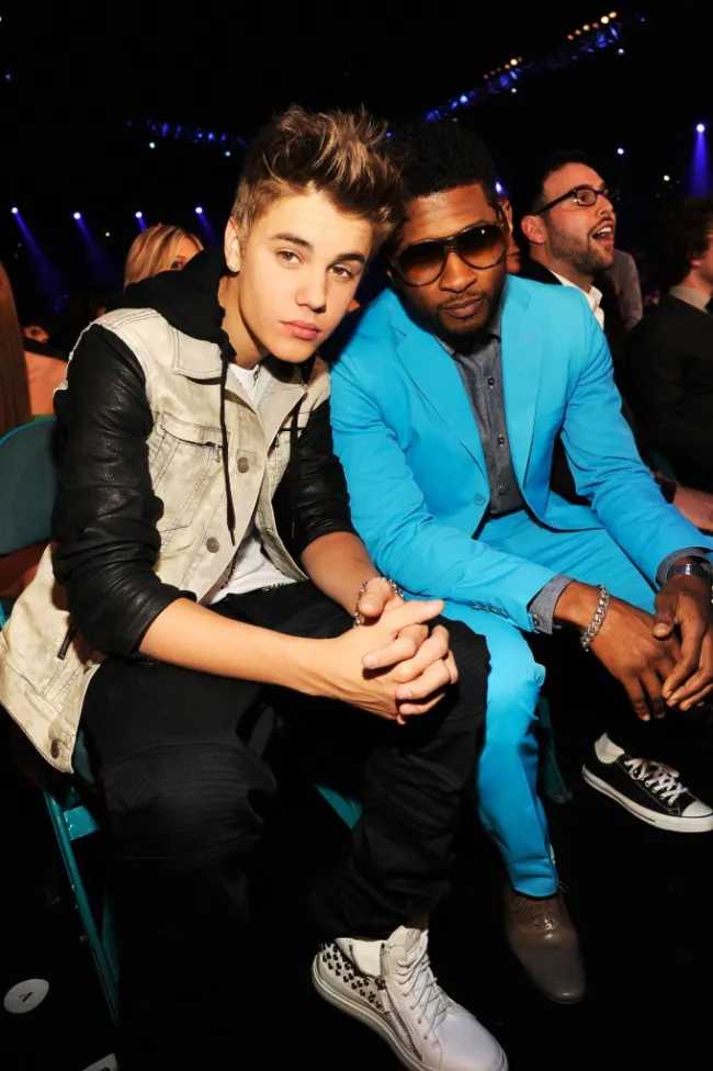 Justin Bieber sentado junto a Usher, en 2012