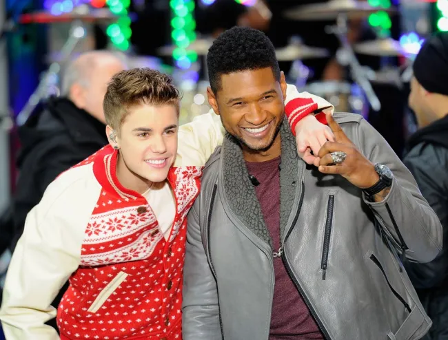 El joven Justin Bieber con el brazo alrededor del hombro de Usher