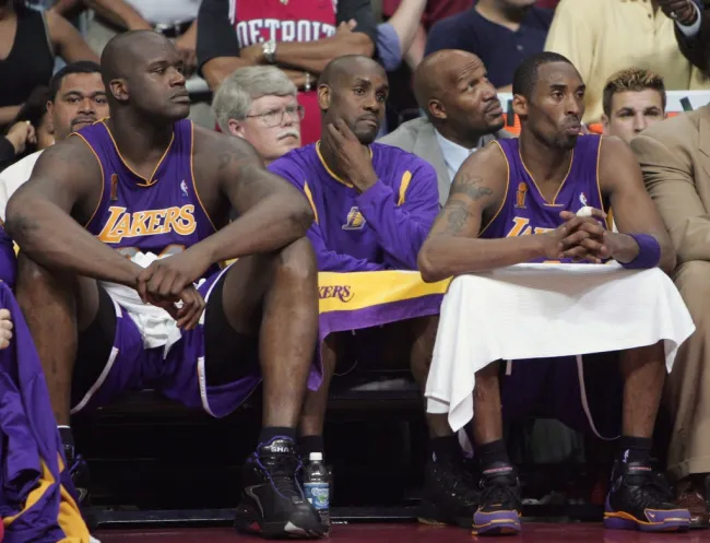 Shaquille O'Neal y Kobe Bryant sentados en un partido de los Lakers.