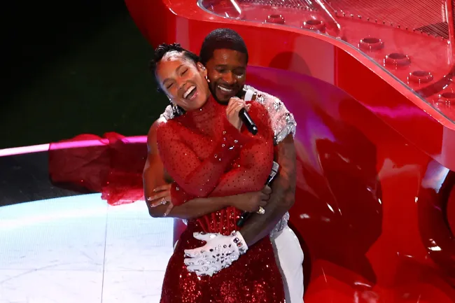 Usher abrazando a Alicia Keys por detrás durante el espectáculo de medio tiempo 2024