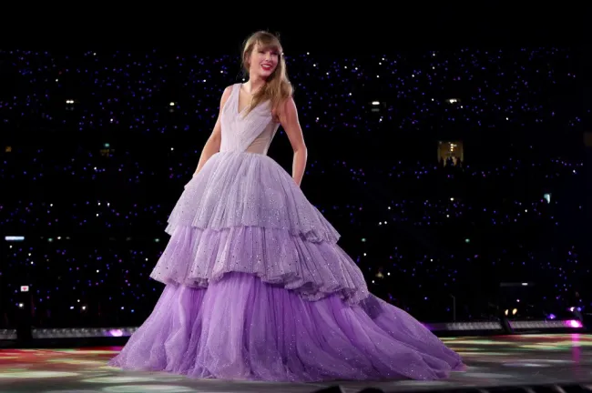 Taylor Swift actuando con un vestido morado de tafetán