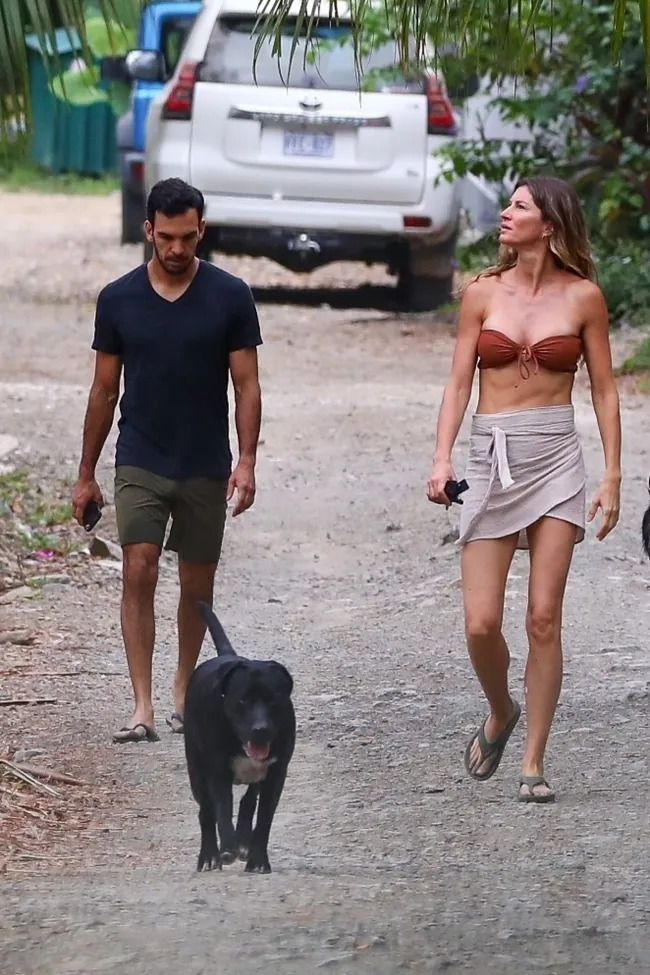 Gisele Bündchen y Joaquim Valente paseando a un perro.