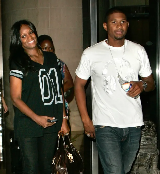 Usher con camiseta blanca y Tameka Foster con camiseta de baloncesto negra.