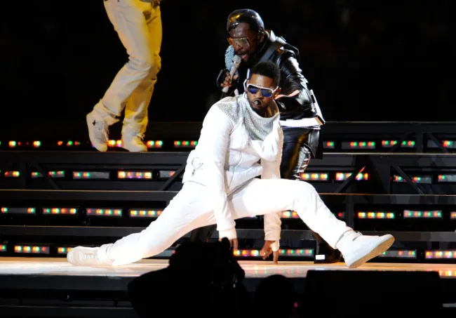 Una foto de Usher y The Black Eyed Peas actuando durante el Super Bowl 2011.