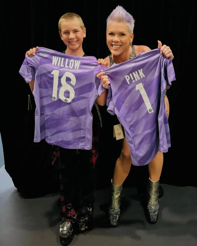 Pink y su hija Willow, sosteniendo camisetas de fútbol.