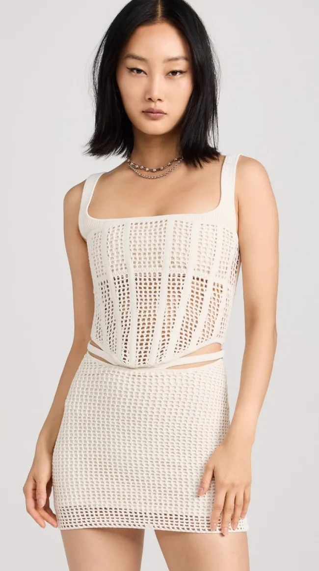 Una modelo con un minivestido de crochet blanco.