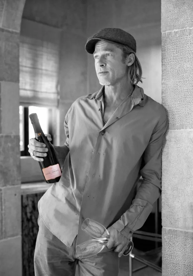 Brad Pitt posa para una foto promocional con una botella de champán Fleur de Miraval.