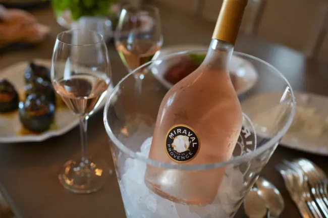 Botella de rosado de Château Miraval en un recipiente con hielo y junto a copas de vino