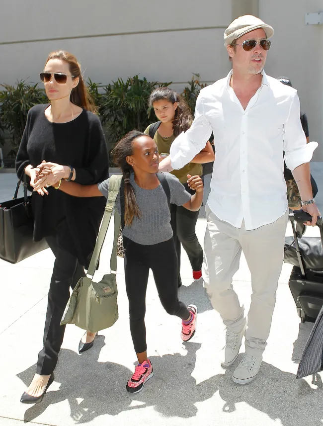 Brad Pitt y Angelina Jolie se dan la mano con su hija Zahara Jolie-Pitt.