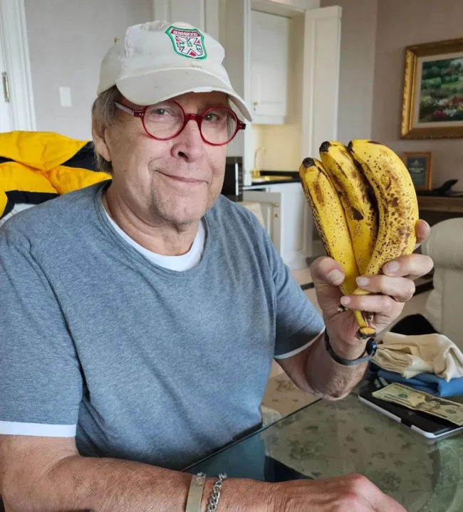 Chevy Chase sosteniendo plátanos.