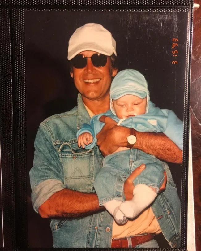 Chevy Chase cargando a su hija Emily cuando era bebé.
