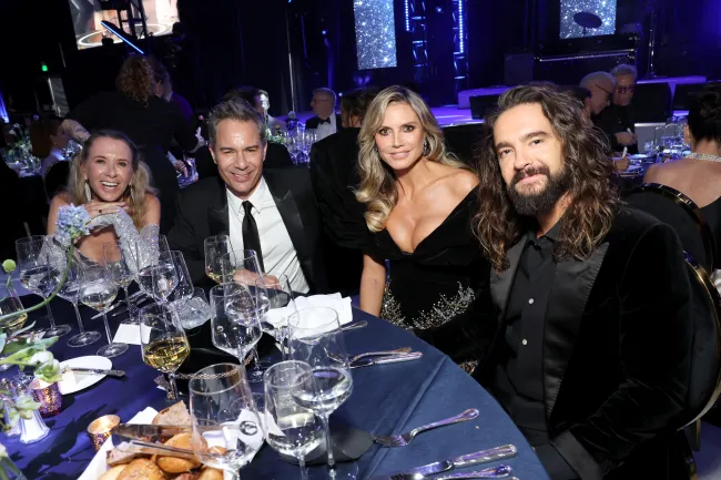 Janet Holden, Eric McCormack, Heidi Klum y Tom Kaulitz sentados en una mesa