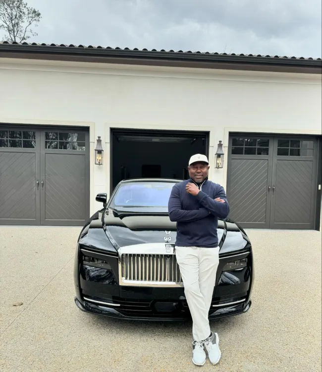 Simon Guobadia posando delante de un Rolls-Royce
