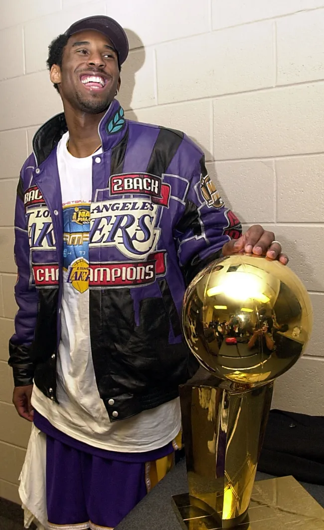 Kobe Bryant de pie con el trofeo del Campeonato de la NBA de 2001.