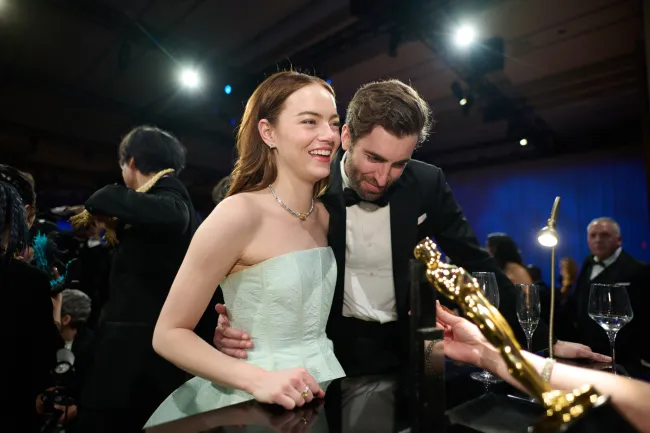 Emma Stone y Dave McCary sonriendo en los Oscar 2024