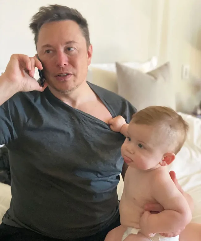 Elon Musk en una llamada con un bebé a su lado.