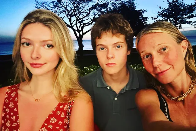 Gwyneth Paltrow y niños en una selfie frente a un océano.
