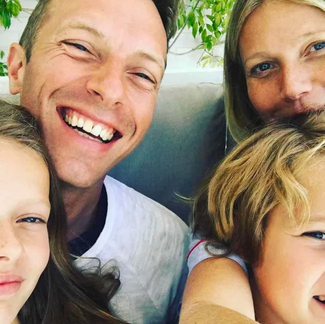 Gwyneth Paltrow, Chris Martin y niños sonriendo en una selfie.