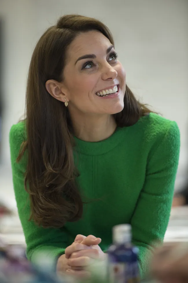 Kate Middleton sonriendo con un vestido verde.