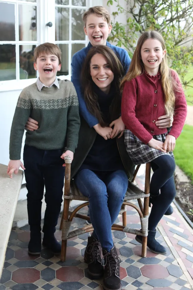 Kate Middleton sentada en una silla rodeada de sus tres hijos.